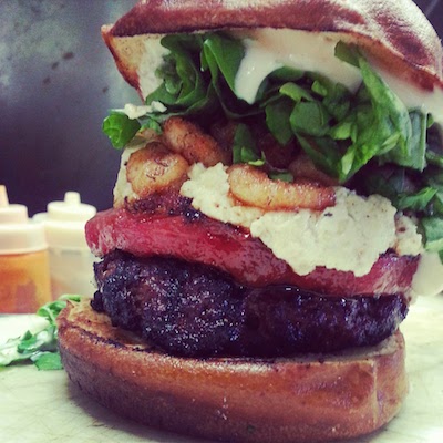 The SWAG Burger, available at Reilly's Lounge, is 1/2 lb highland beef patty topped with "vac-seal pressed" grilled watermelon, toasted almond infused goat cheese, fried coldwater shrimp, spinach and home made baconnaise served on a pretzel bun.